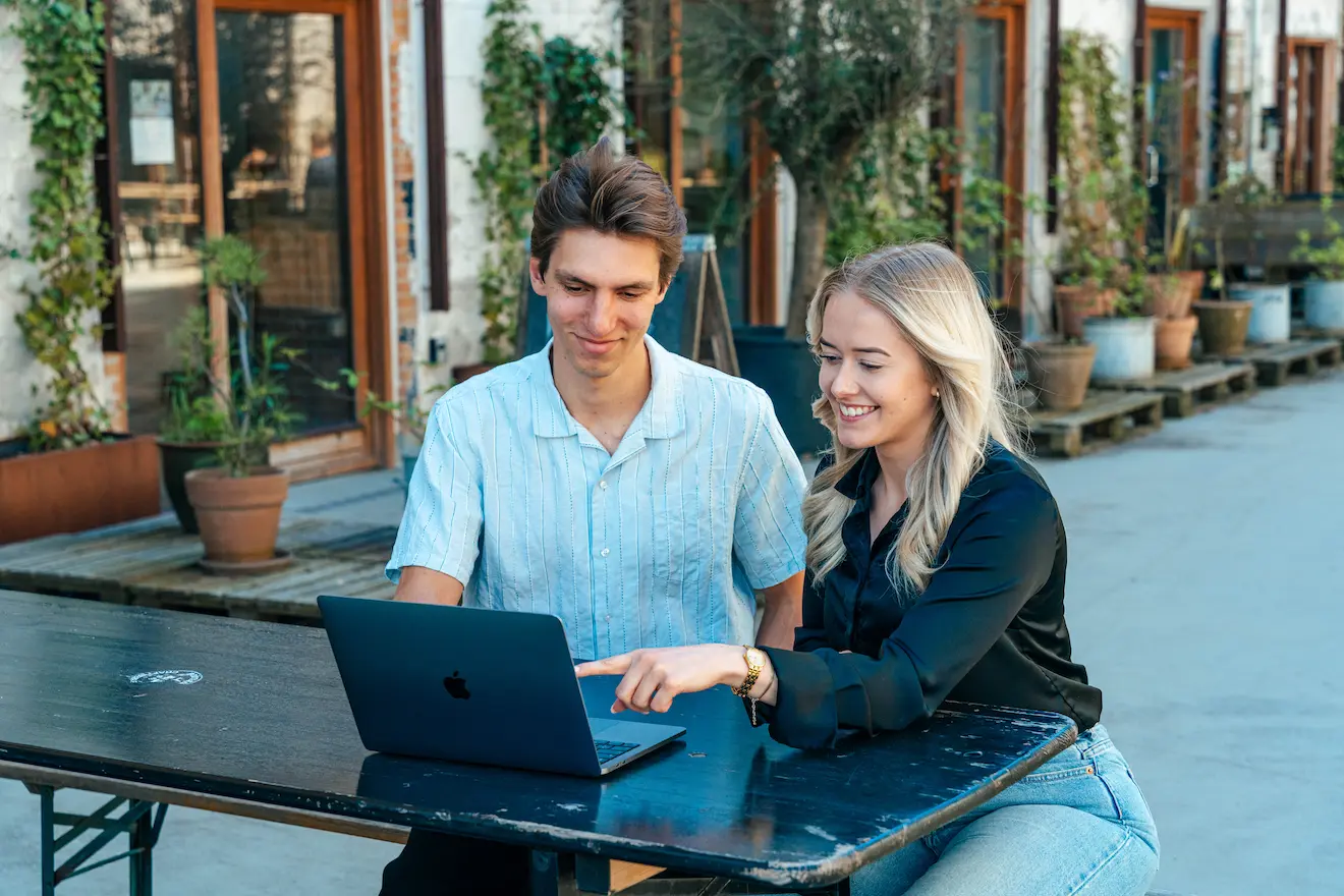 To mennesker der arbejder sammen på en computer