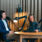 To mennesker der sidder sammen i et podcaststudie og har det sjovt