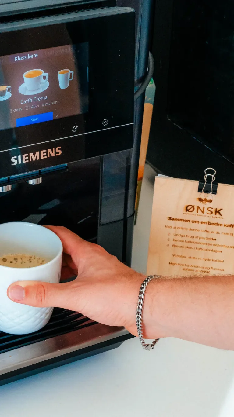 En hånd der tager en kaffekop